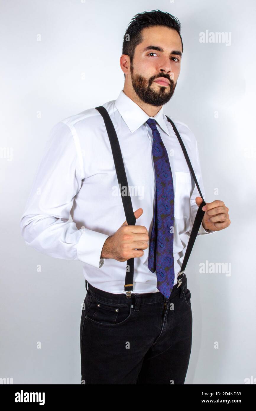 Handsome young businessman pulling his suspenders. Attractive