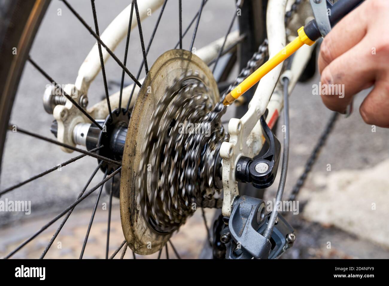 A person is oiling the gear of a bicycle with an oil can Stock Photo