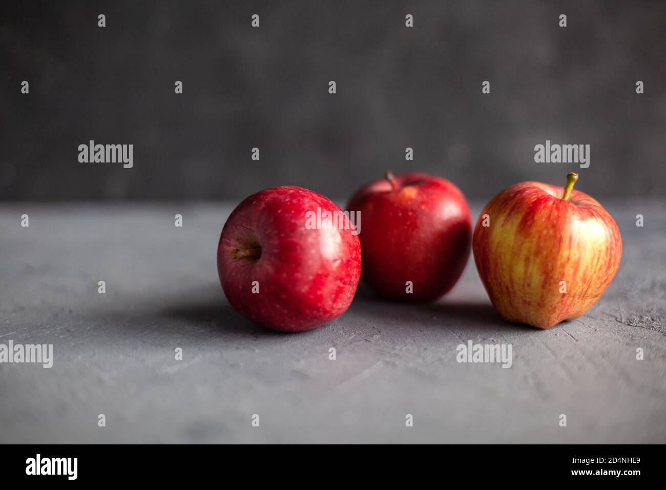 three-ripe-garden-red-apples-on-gray-concrete-fruits-concept-of-the