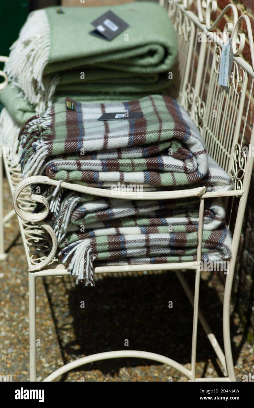 Patterned cloths or plaids consisting of criss-crossed, horizontal and vertical bands, also known as Tartan, for sale on a garden bench in the UK Stock Photo