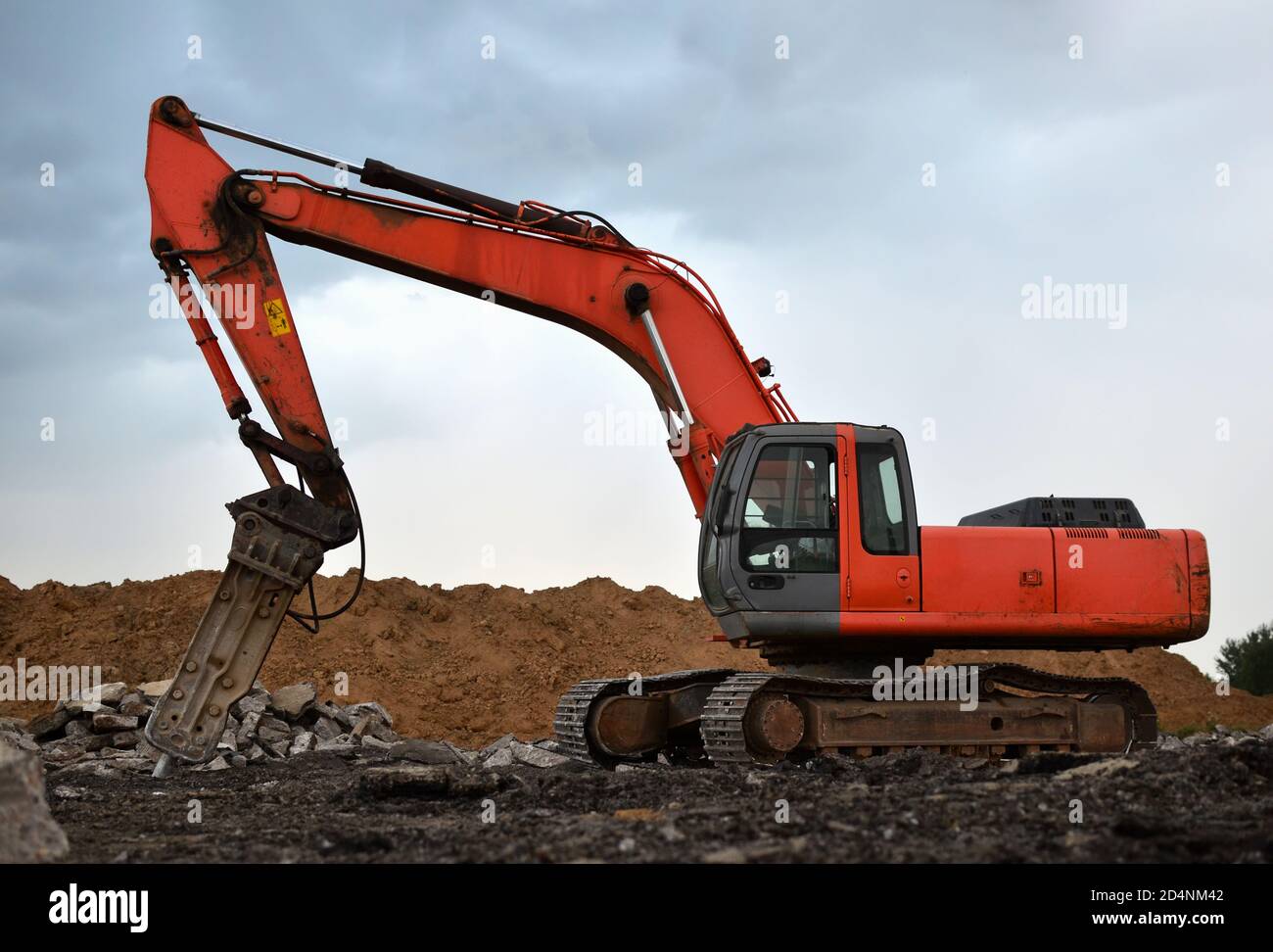 Excavator with hydraulic breaker hammer at construction site