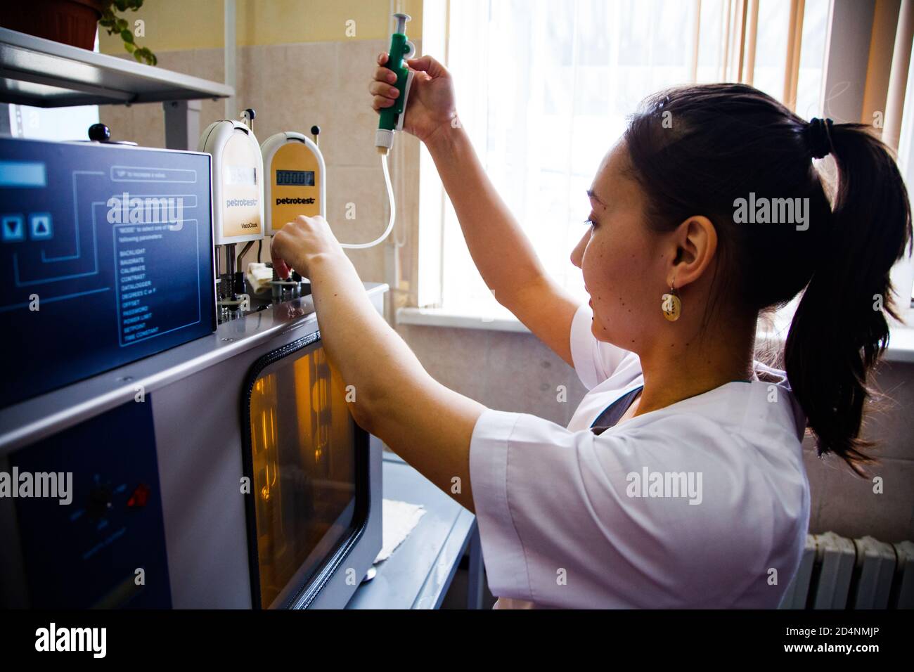 Motor oil modern production plant. Chemical lab. Young Asian woman