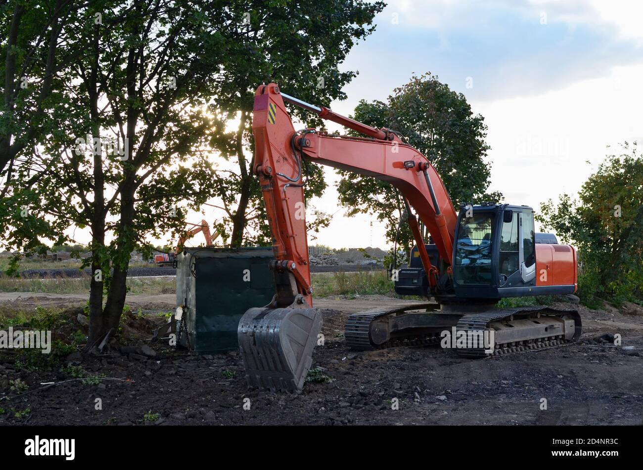 Bucked tracked excavator digs ground at a construction site for