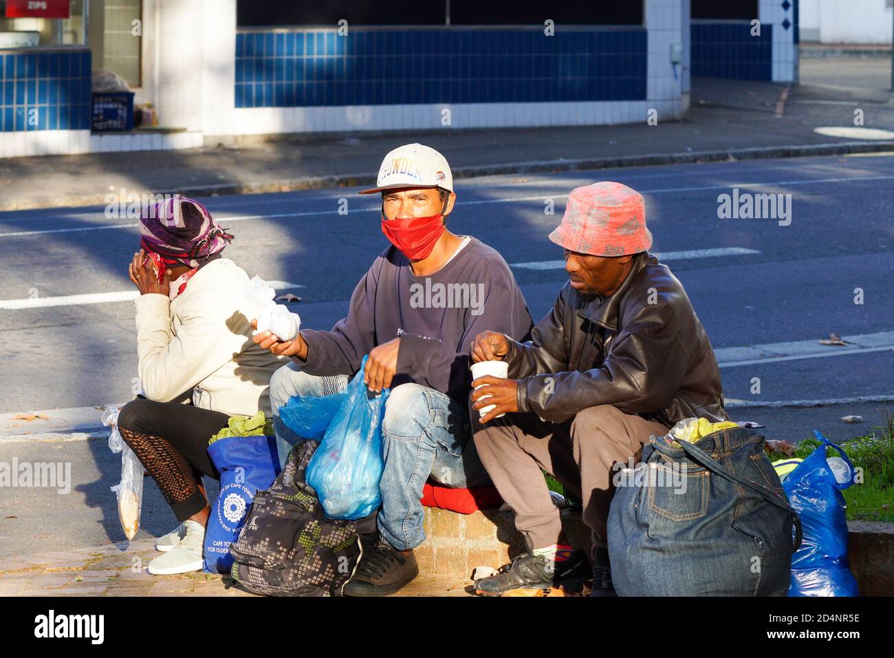 homeless and destitute people sitting in a street with a mask on during lockdown in Cape Town, South Africa during the corona virus pandemic Stock Photo