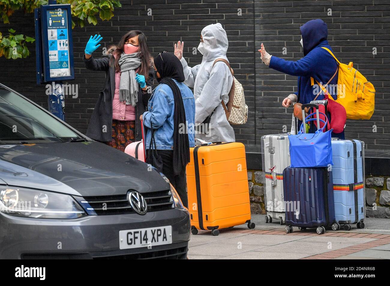 Students wear PPE as they wave goodbye to a friend as they wait for transport to take them to their student accommodation in Bristol, where hundreds of students have been told to self-isolate after 40 people have tested positive for Covid-19. Stock Photo