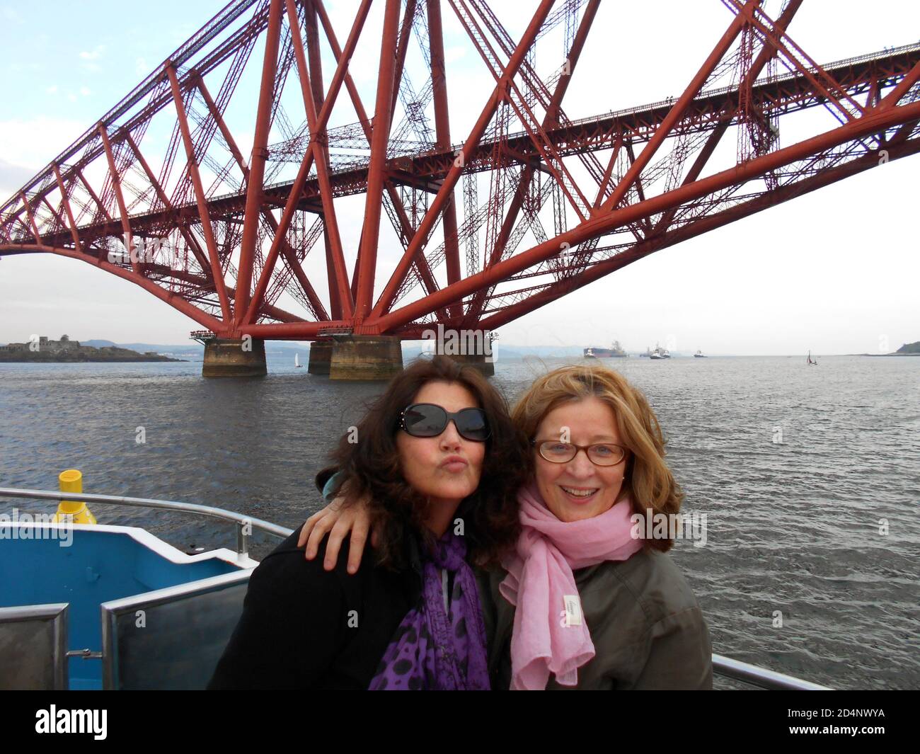 Two pals are enjoying a boat trip on the Firth of Forth which goes under the huge, magnificent and stunning Forth Bridge. It is a world heritage site and has to be seen in all it's splendour. ALAN WYLIE/ALAMY ©. Stock Photo