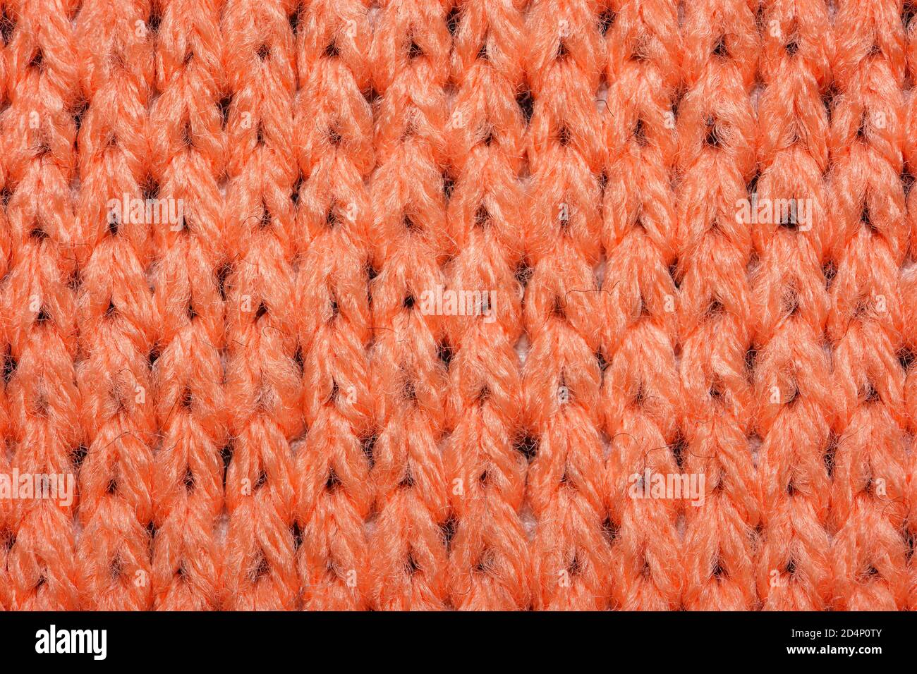 Red synthetic knitted fabric close up. Knitted fabric texture background Stock Photo