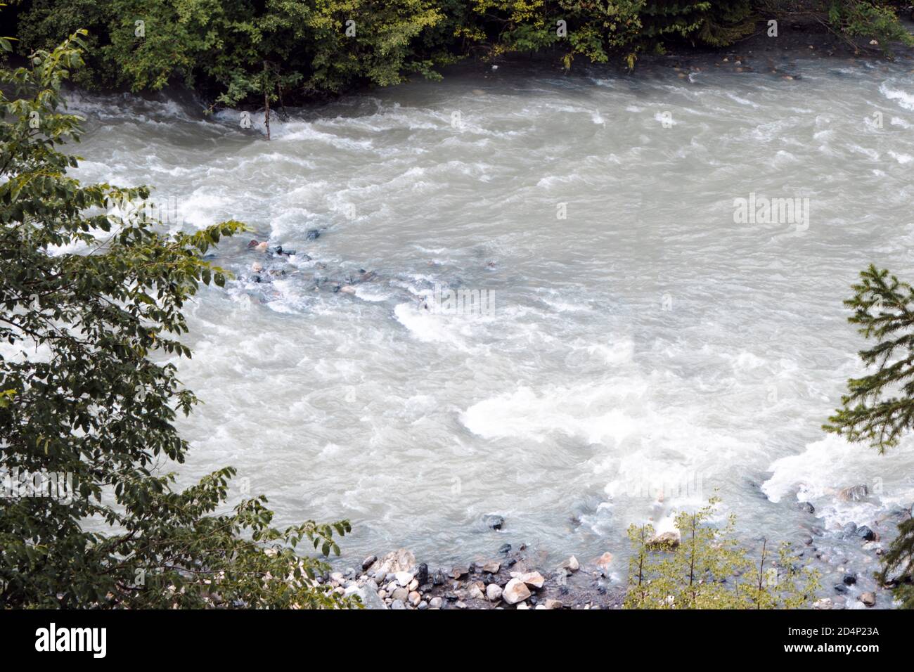 the water of a stormy mountain river flowing among stones and boulders ...