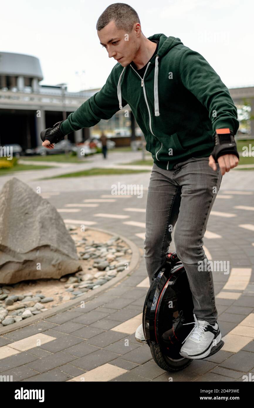 Man riding electric mono cycle on street Stock Photo