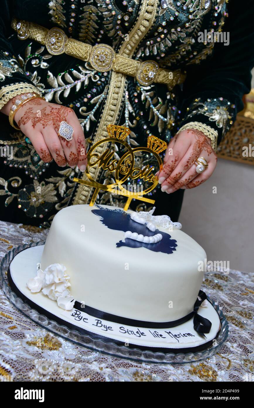 Moroccan henna. Hand of a Moroccan bride tattooed with henna holding a wedding cake Stock Photo