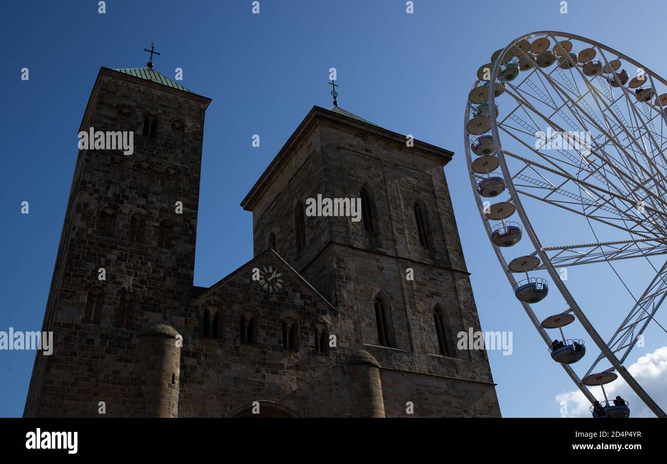 10 October 2020, Lower Saxony, Osnabrück: A Ferris wheel stands in front of the Osnabrück Cathedral. Due to the corona pandemic, this year there will be no fair at Halle Gartlage, but a so-called 'special market' on the cathedral forecourt. Photo: Friso Gentsch/dpa Stock Photo