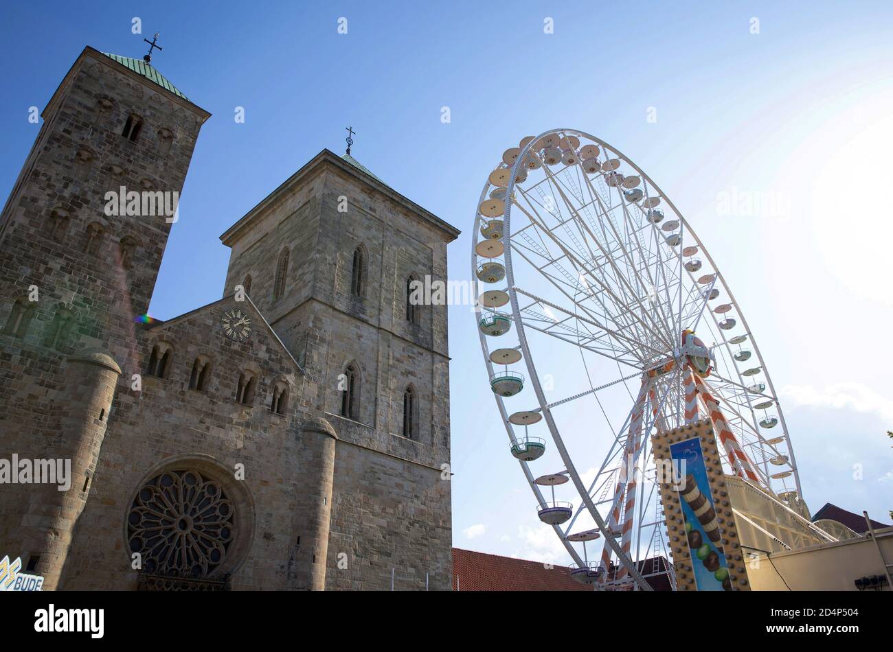 10 October 2020, Lower Saxony, Osnabrück: A Ferris wheel stands in front of the Osnabrück Cathedral. Due to the corona pandemic, this year there will be no fair at Halle Gartlage, but a so-called 'special market' on the cathedral forecourt. Photo: Friso Gentsch/dpa Stock Photo