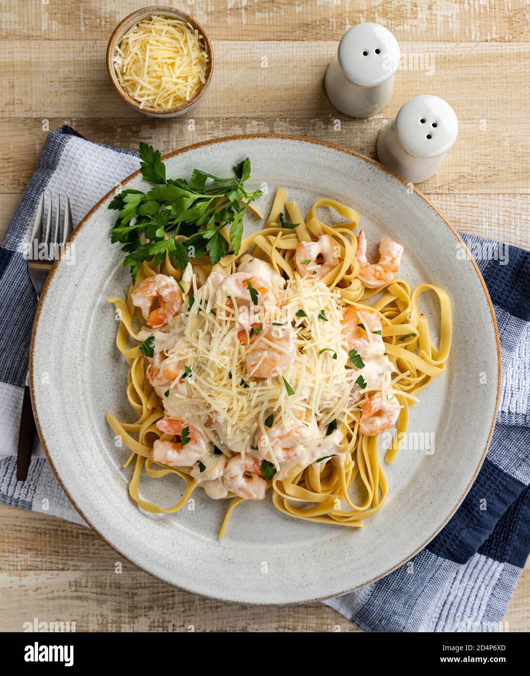Creamy fettuccine alfredo with shrimp and shredded parmesan cheese on a