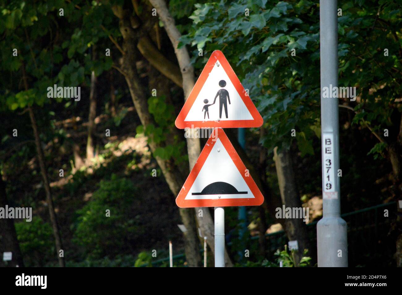 Hong Kong traffic warning signs (pedestrians on or crossing road ahead, road hump ahead) Stock Photo