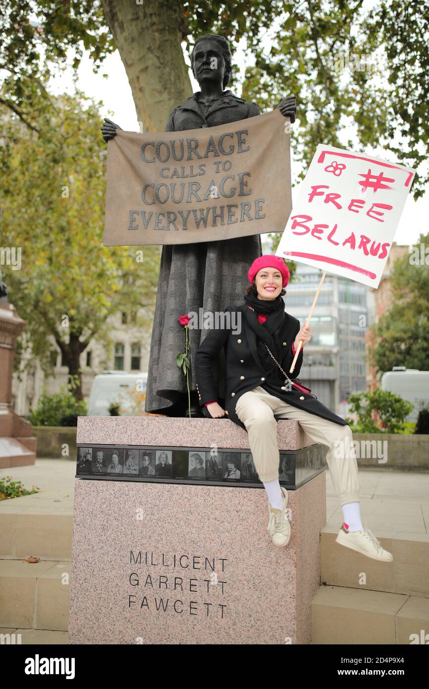 A woman sitting on the plinth of the statue of Millicent Garrett Fawcett in Parliament Square, during the march, in solidarity with the women of Belarus, to Downing Street, London. Stock Photo