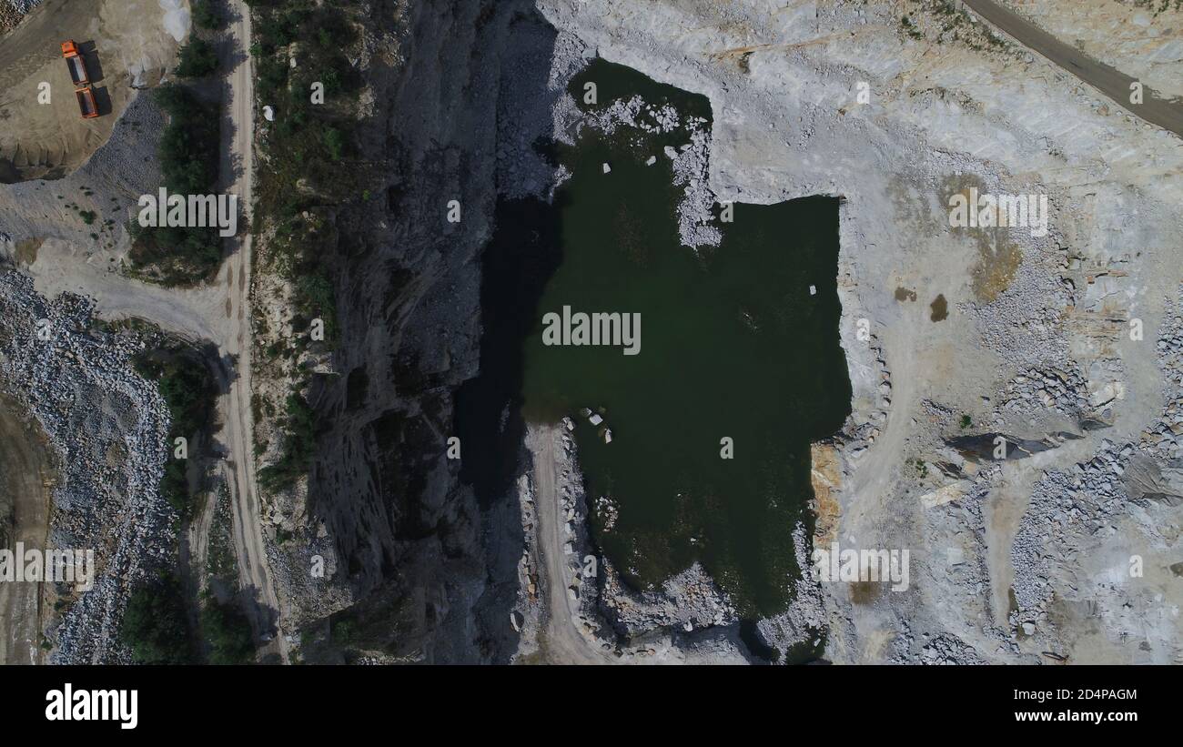 Aerial view of opencast mining quarry with lots of machinery at work ...