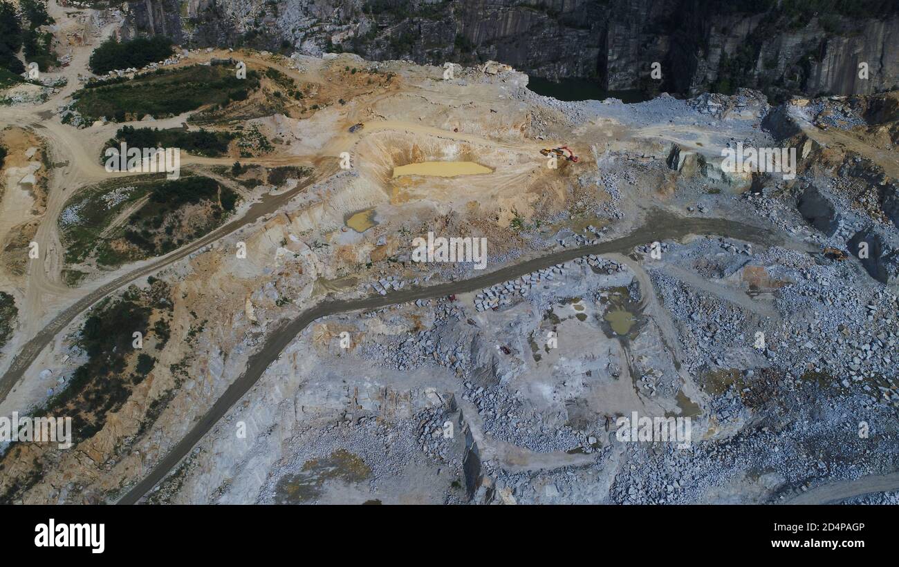 Aerial view of opencast mining quarry with lots of machinery at work ...