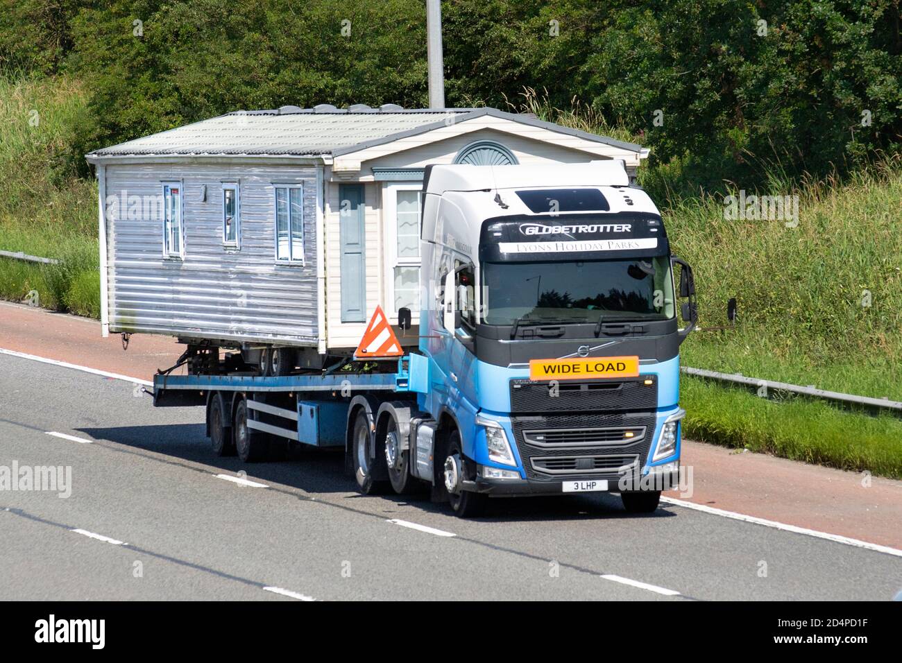 Lyons Holiday Parks caravan Sales & transport; Haulage delivery trucks, lorry, transportation, wide-load truck, cargo carrier, long-distance heavy-duty Volvo trucks, Volvo  vehicle, European commercial transport industry HGV, M6 at Manchester, UK Stock Photo