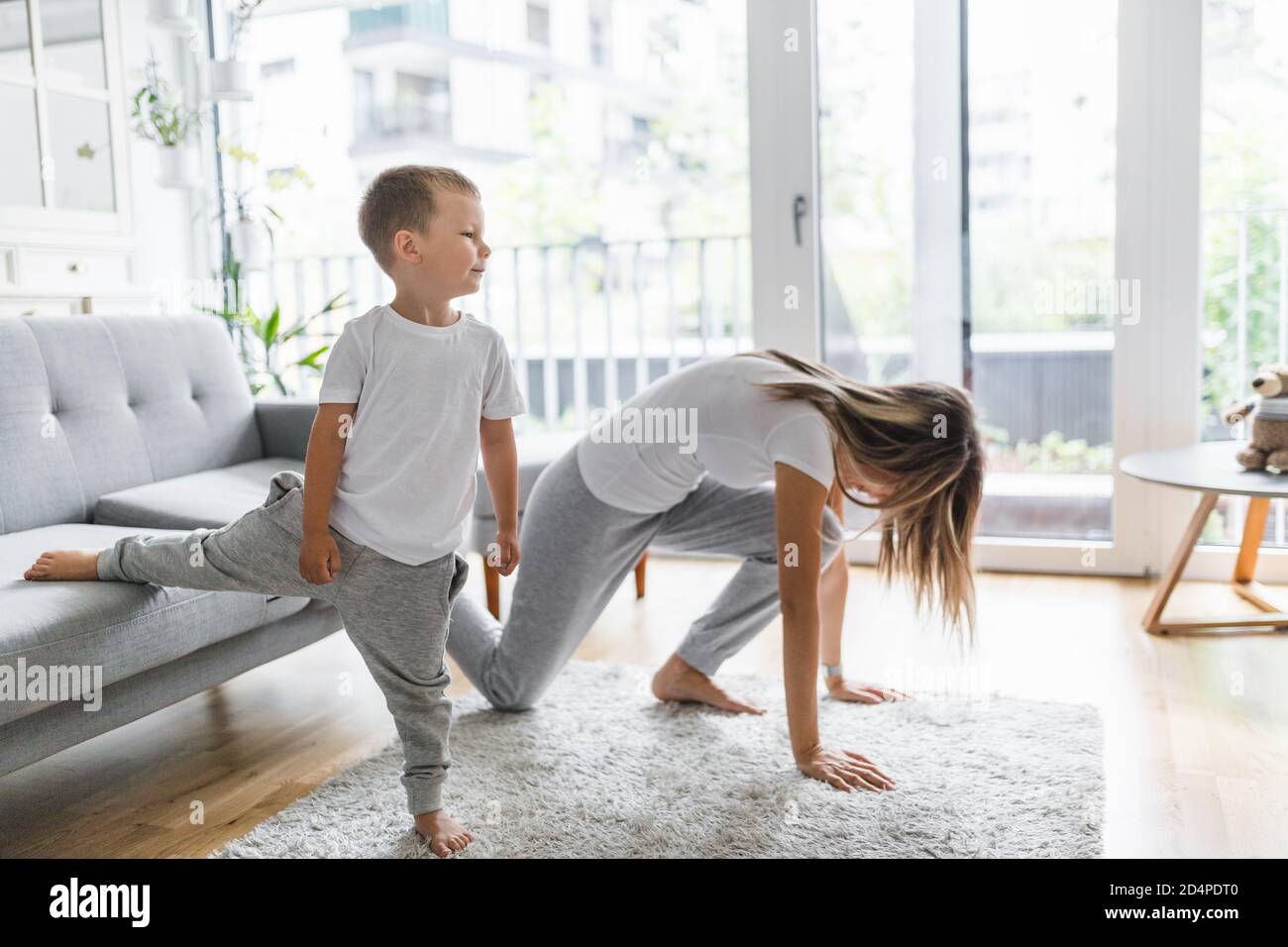 Mom with her young son working out in the living room Stock Photo