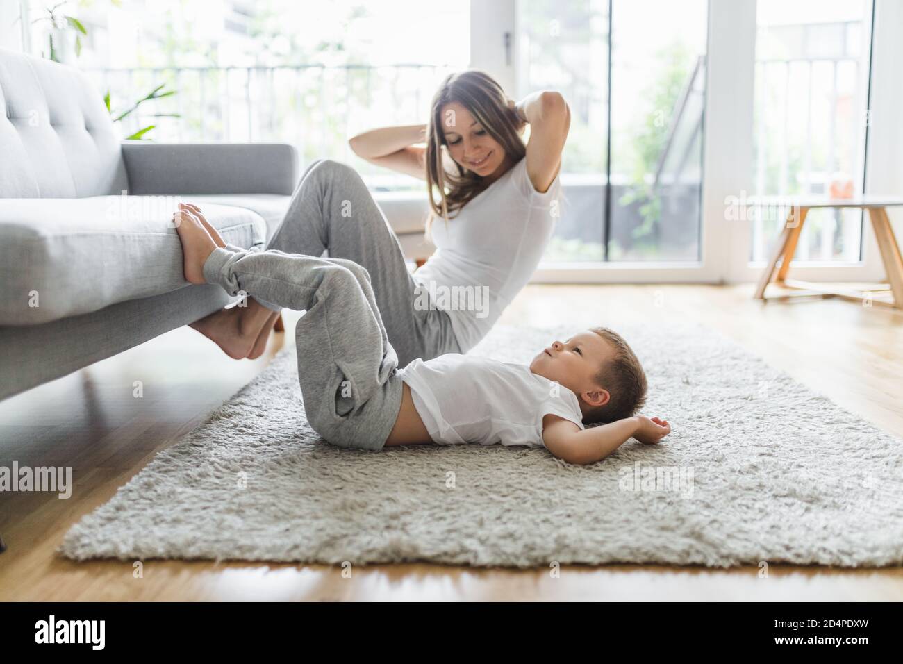 Mom with her young son working out in the living room Stock Photo