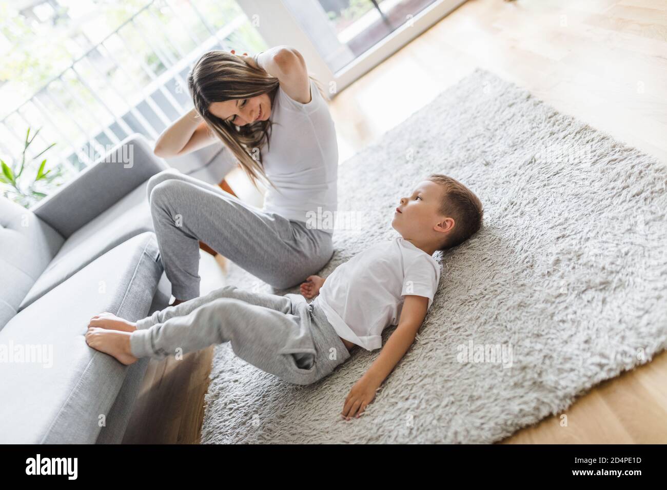 Mom with her young son working out in the living room Stock Photo