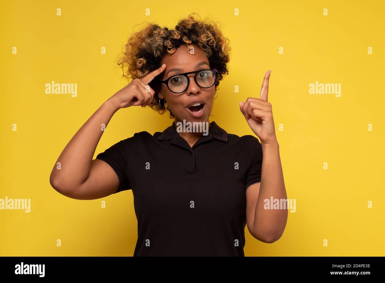 African young woman with curly hair having idea pointing with finger up Stock Photo