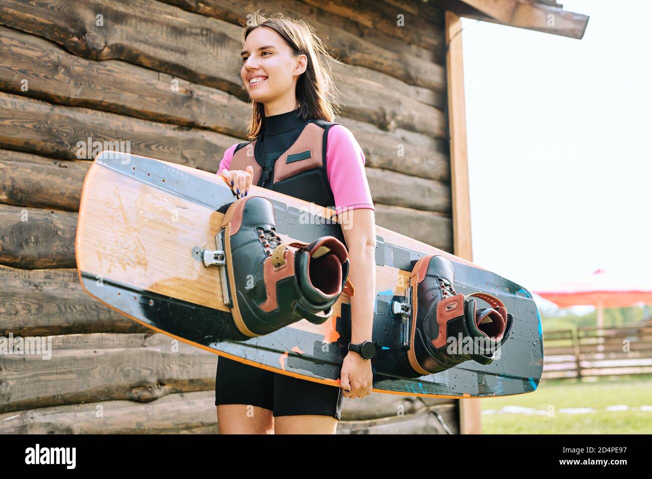 Young smiling surfer in sportswear carrying surfboard while going for  training Stock Photo - Alamy