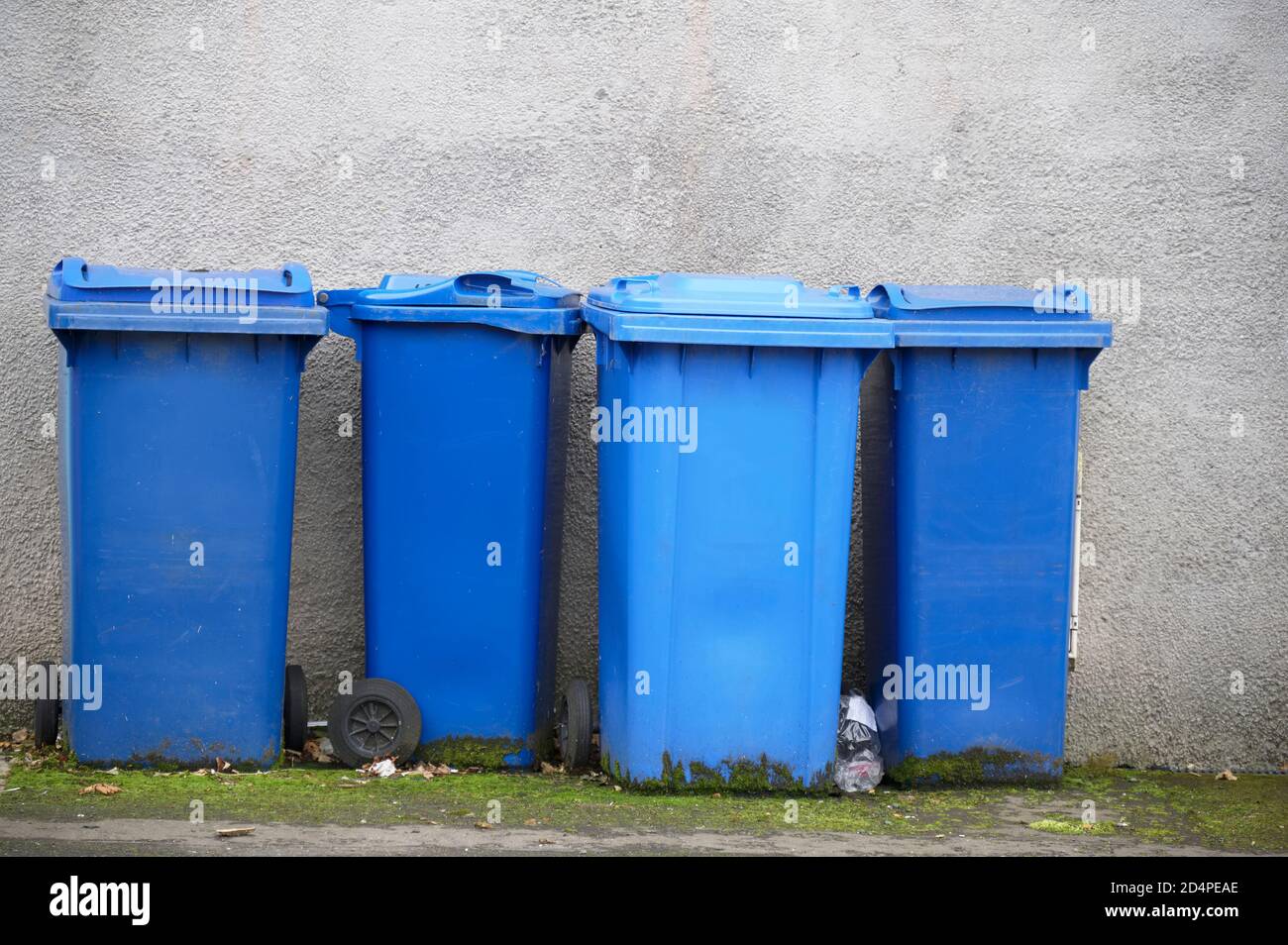 Blue recycle wheelie bins in row for collection outside house Stock