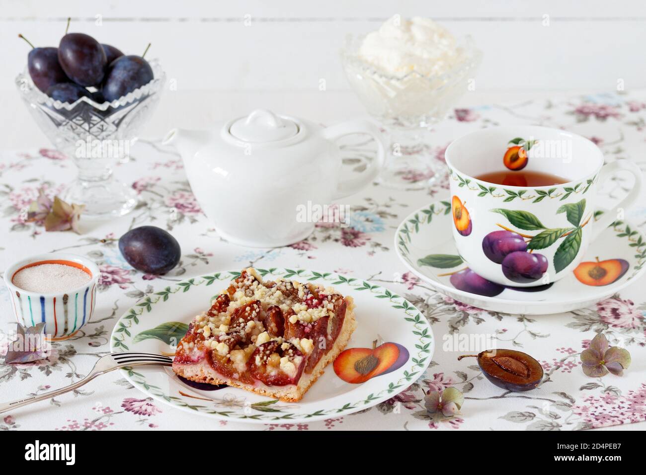 plum slice with crumble topping, cup of tea and whipped cream Stock Photo