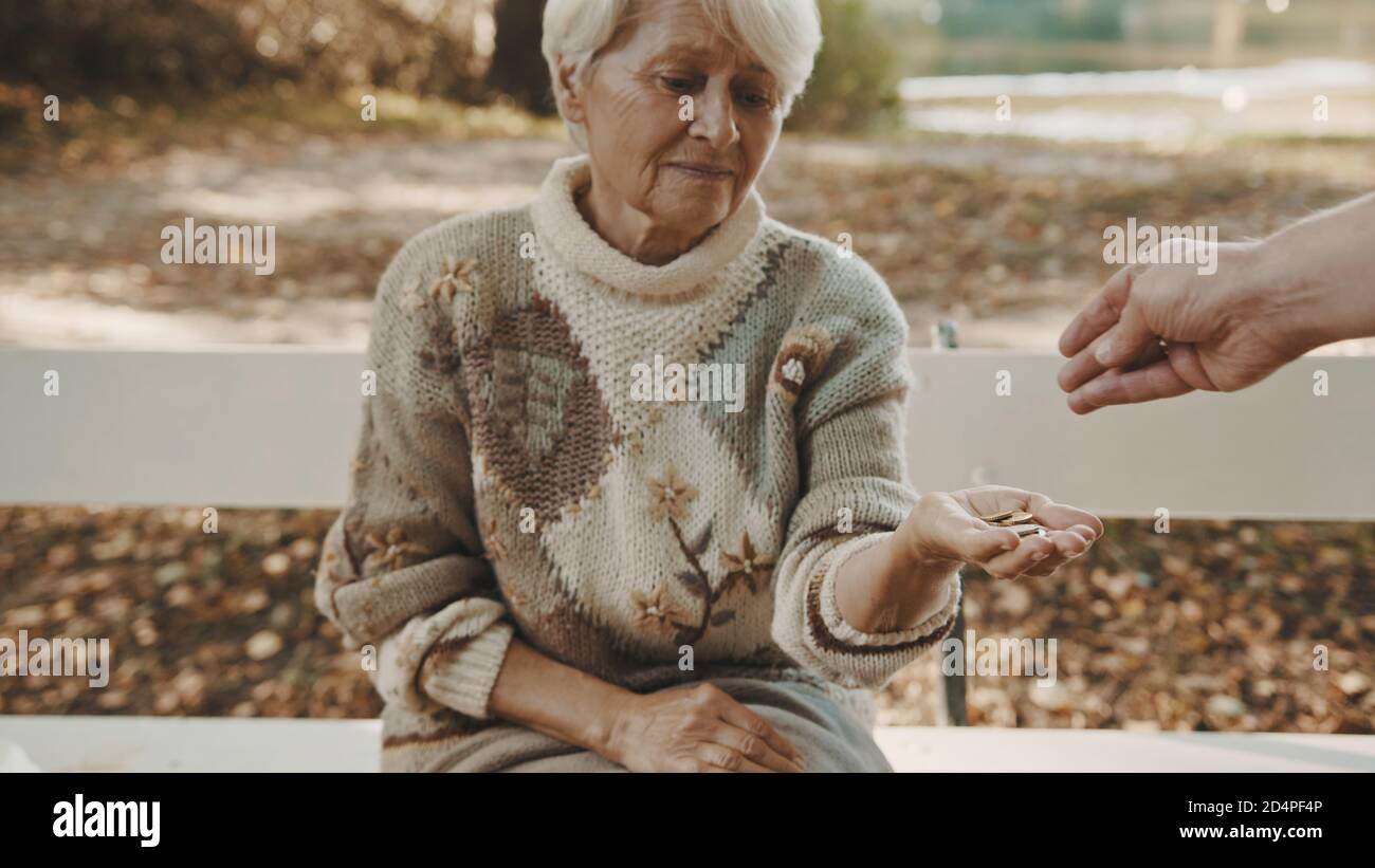 Old poor woman getting some coins from passenger. High quality photo Stock Photo