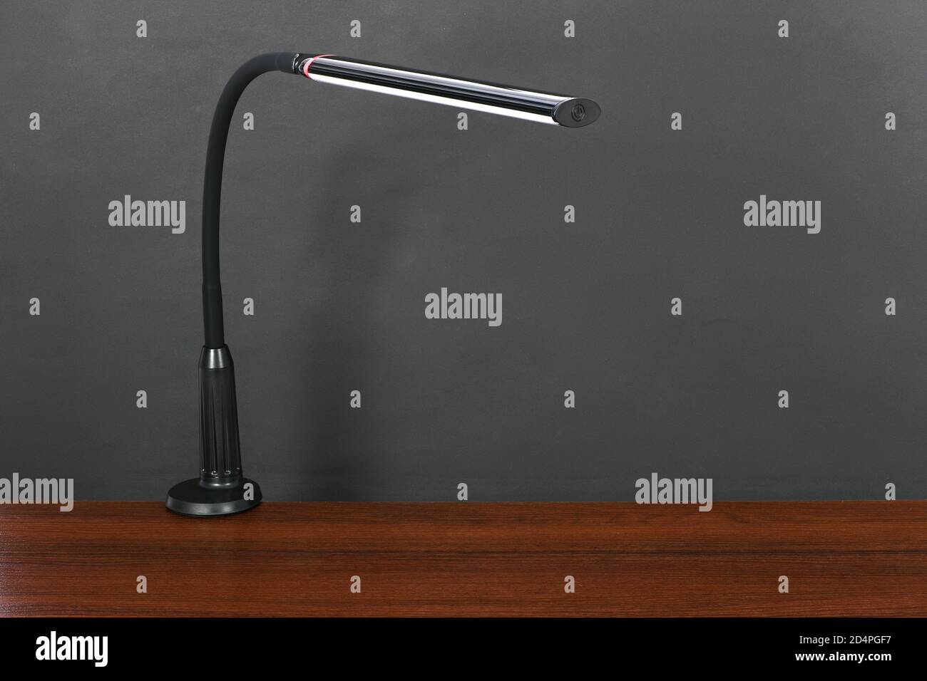 Modern black flexible desk lamp isolated on black background. High resolution photo. Full depth of field. Stock Photo