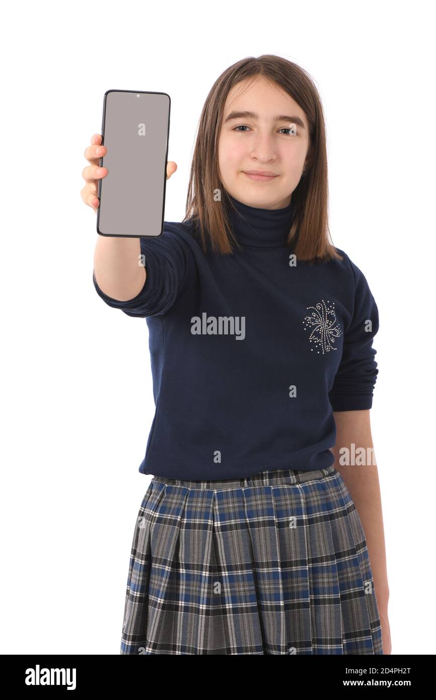 Pre-adolescent girl holding black smartphone with blank screen. isolated on white background. High resolution photo. Full depth of field. Stock Photo