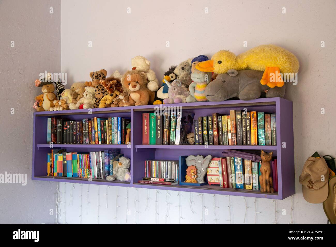 Shelf with books and soft fluffy toys in a children's bedroom Stock Photo