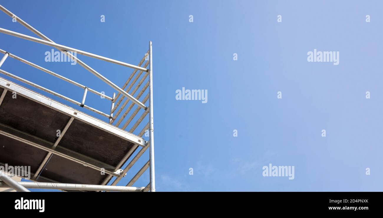 Scaffolding, metal mobile scaffold aginst blue sky background. Under construction, maintenance renovation works concept Stock Photo