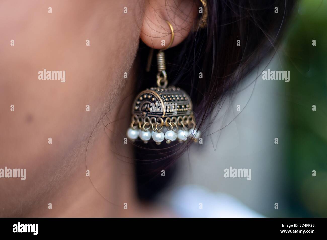 Closeup girl wearing Indian style earrings or Jhumka. Stock Photo