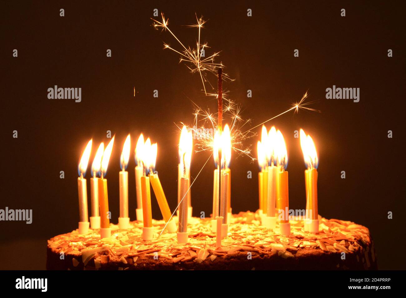 Lit candles on birthday cake Stock Photo Alamy