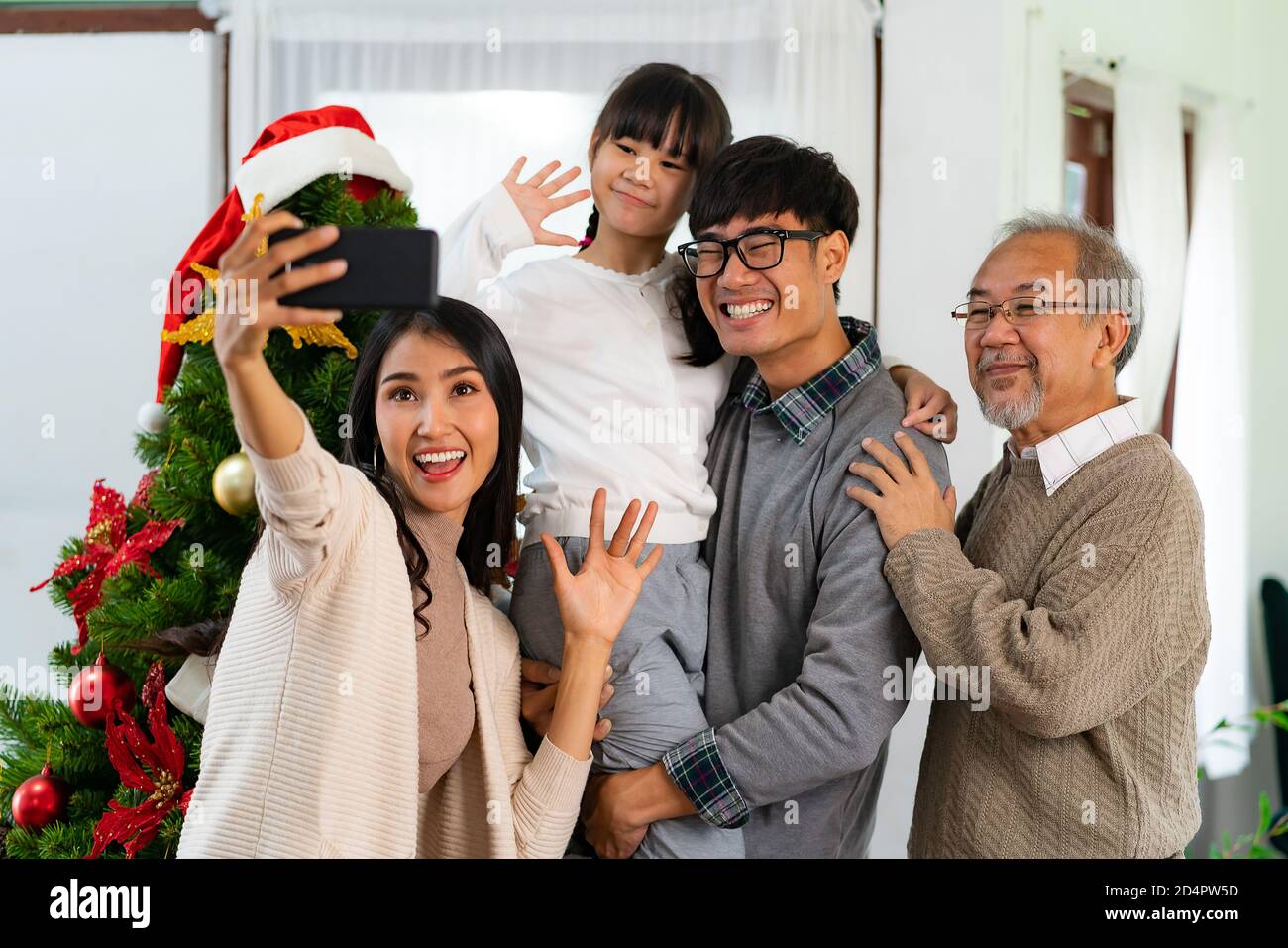 Multigenerational asian Family ,Mom Dad daughter girl and grandfather ,selfie with a Christmas tree after decorate the Christmas ornament prepare seas Stock Photo