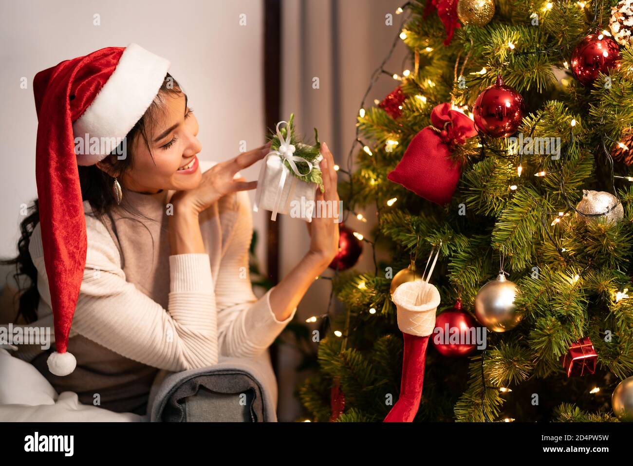 Beautiful asian woman holding Christmas ornament for decorate on christmas tree preparing for season greeting of merry christmas and happy holiday. Stock Photo