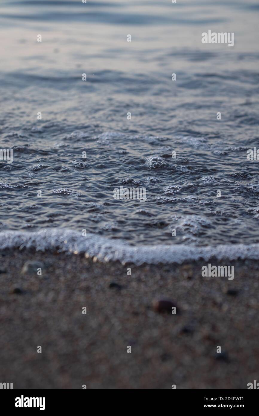 Close-up of waves and bubbles seaside, clear blue water Stock Photo