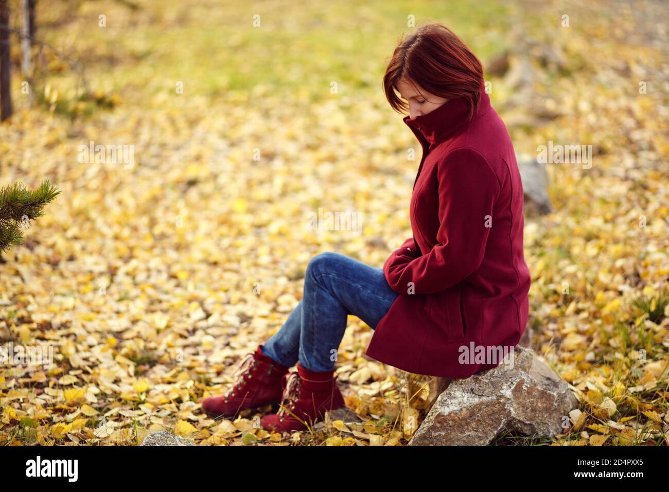 portrait of a sad redhead woman with yellow leaves in autumn Stock ...