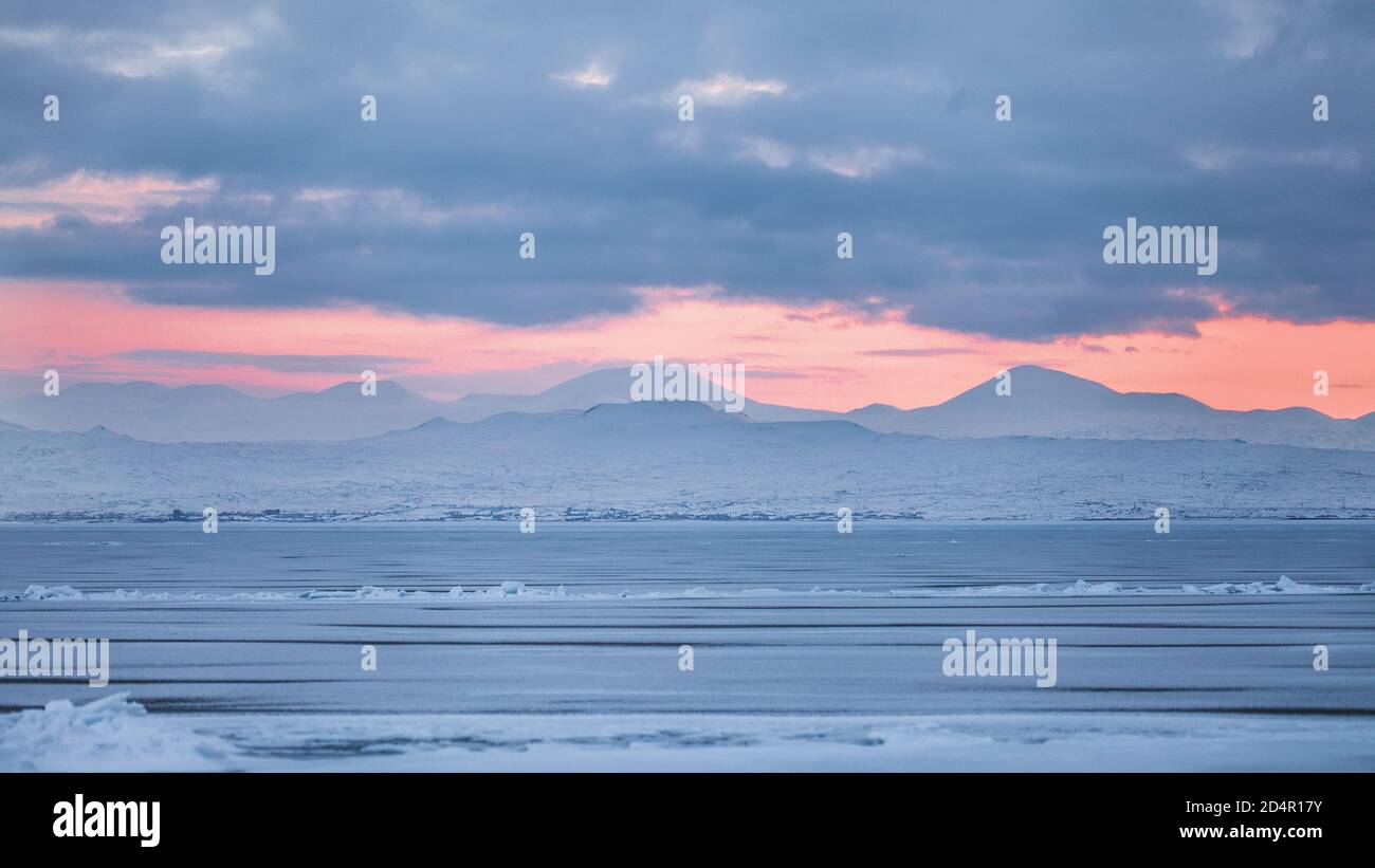 Beautiful view of frozen Lake Sevan on a winter day during the orange sunset Stock Photo
