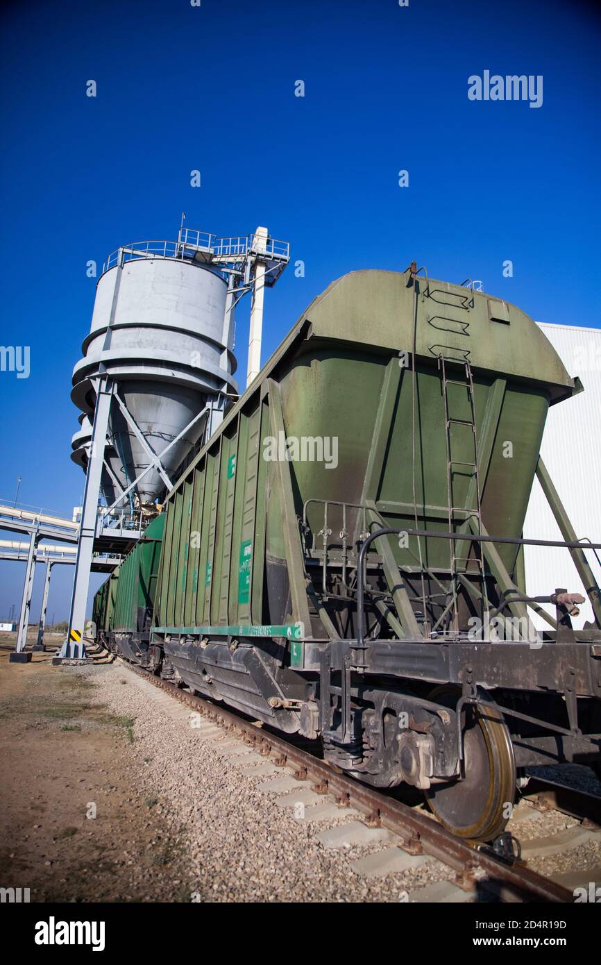 Phosphate fertilizers plant. Railway  loader station of fertilizers. Phosphate fertilizers plant. Hopper car train terminal. Green railway carriages. Stock Photo