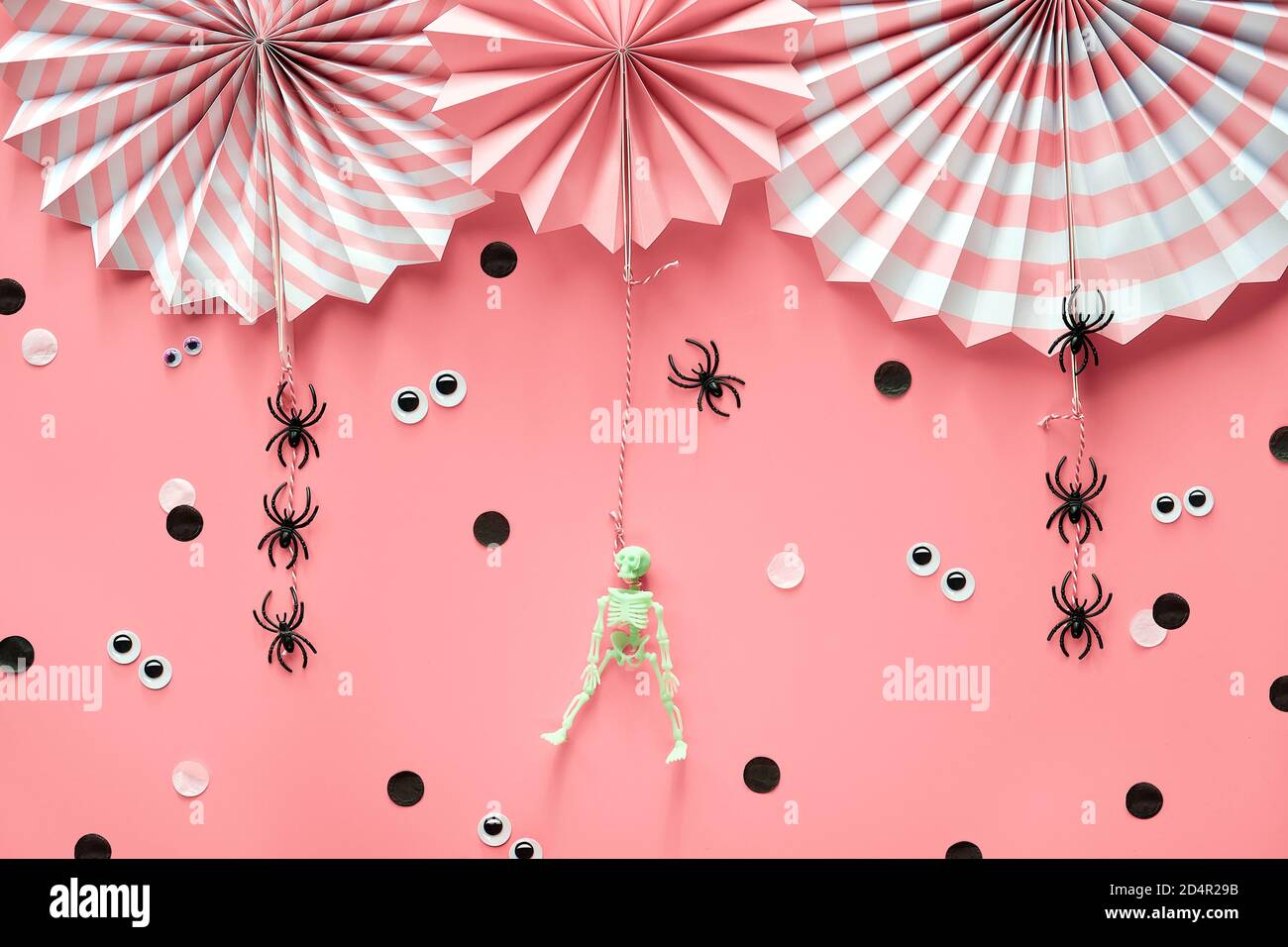 Pink Halloween decorations. Decorative paper fans, spiders, skeleton