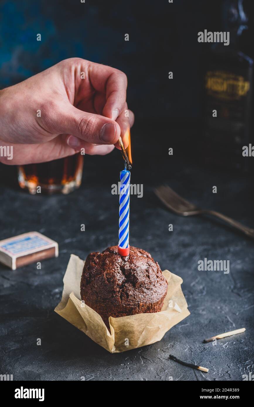Hand lighting candle on birthday muffin Stock Photo Alamy