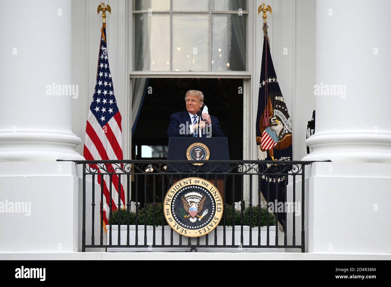 Washington, DC, USA. 10th Oct, 2020. U.S. President Donald Trump removes a protective mask ahead of speaking from the Truman Balcony of the White House in Washington, DC, U.S., on Saturday, Oct. 10, 2020. Trump, making his first public appearance since returning from a three-day hospitalization for Covid-19, is setting the stage for a return to the campaign trail even as questions remain about whether he's still contagious. Photographer: Erin Scott/BloombergCredit: Erin Scott/Pool via CNP | usage worldwide Credit: dpa/Alamy Live News Stock Photo