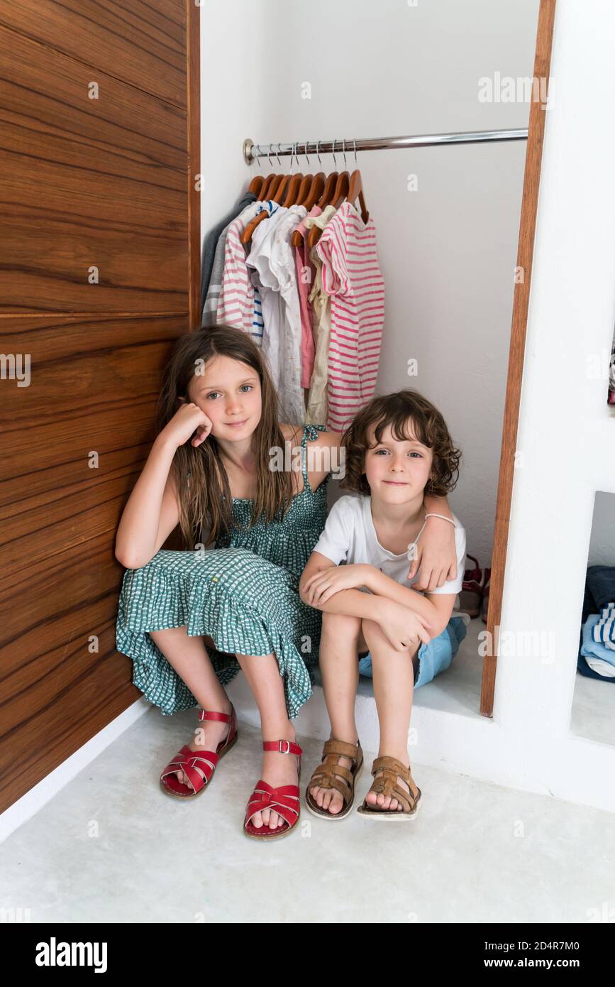 Children having put away the closet of clothes from their room. Stock Photo