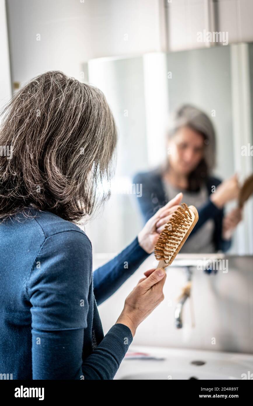 Woman brushing her hair. Stock Photo