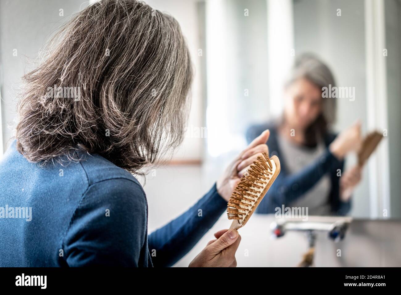 Woman brushing her hair. Stock Photo