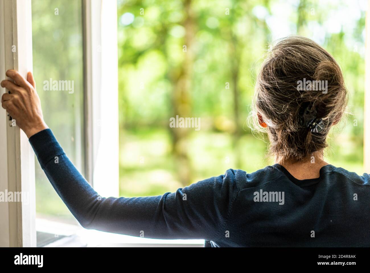Woman opening window Stock Photo - Alamy
