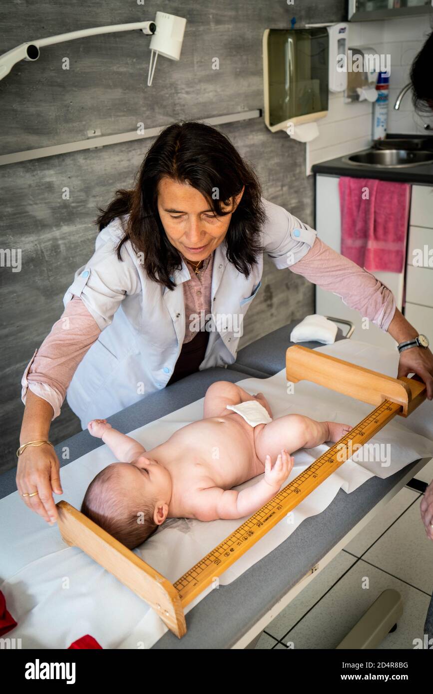 General practitioner with baby, Medical cabinet Pélissier, Réalmont, France. Stock Photo